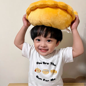 cute boy playing with egg tart plushie in his wee bean bakery buns organic cotton tee