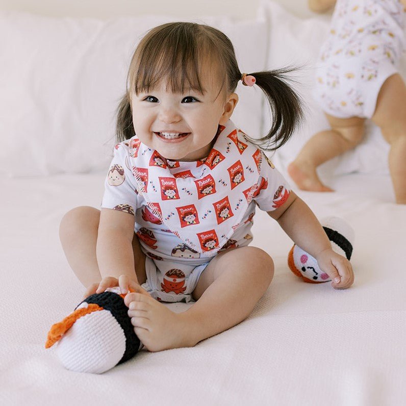 cute baby laughing wearing the wee bean organic cotton bib in milky candy