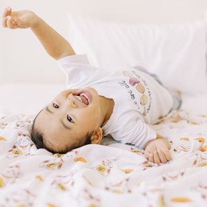 little boy playing on the super soft lucky cat swaddle